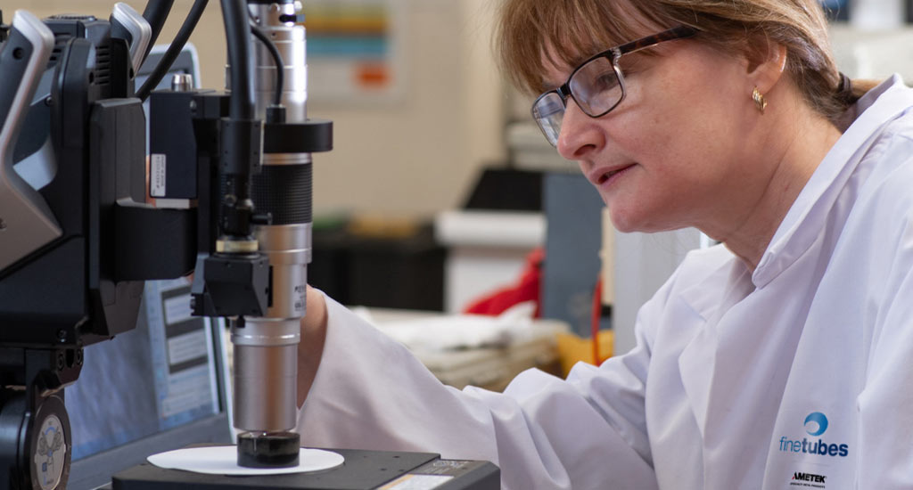A worker perfoms a quality check of seamless tubing to ensure safety and quality standards